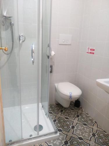 a bathroom with a shower with a toilet and a sink at Riparo di Masseria Urbana in Crispiano