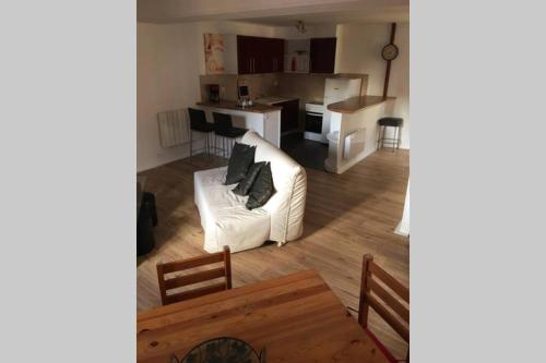 un salon avec un canapé blanc et une cuisine dans l'établissement Appartement 4 couchages , équipé de la fibre, à Briare