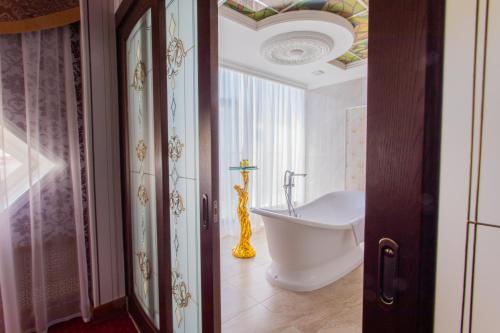 a bathroom with a tub and a sink in a room at Polaris in Surgut