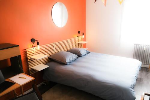 a bedroom with a large bed with an orange wall at Le Grand Chambord 2 in Laval