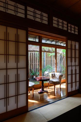 a room with sliding doors and a table and chairs at Kappo Ryokan Yumesaki in Beppu
