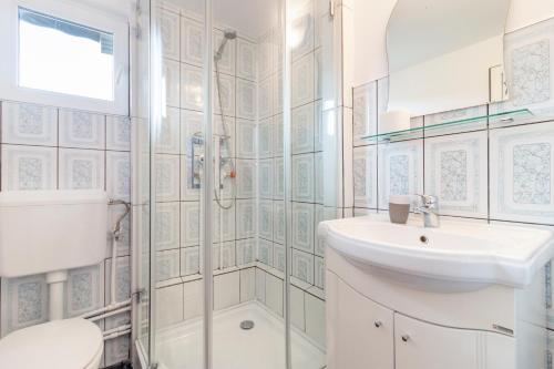 a white bathroom with a sink and a shower at Casa Elia in Bran