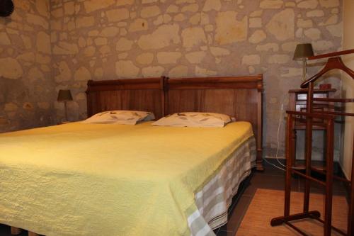 - une chambre avec un grand lit et une couverture jaune dans l'établissement Logis de la Pichonnière, à  Charcé-Saint-Ellier-sur-Aubance