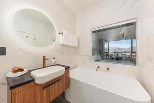 W łazience znajduje się wanna, umywalka i lustro. w obiekcie Galaxy Boutique Hotel w mieście Lake Tekapo