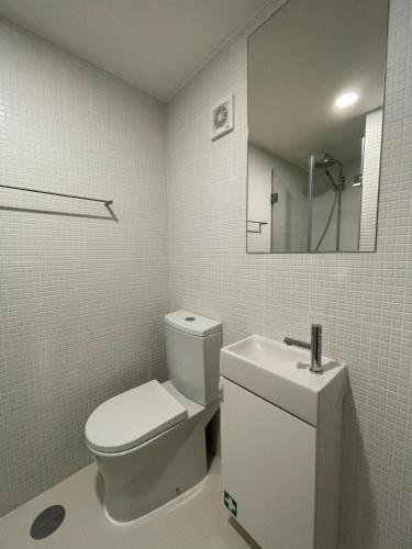 a white bathroom with a toilet and a sink at Sweet Love Family II in Coimbra