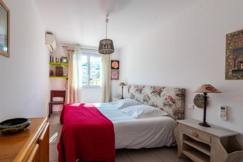 une chambre avec un lit, une table et une fenêtre dans l'établissement Le Lympia, à Nice