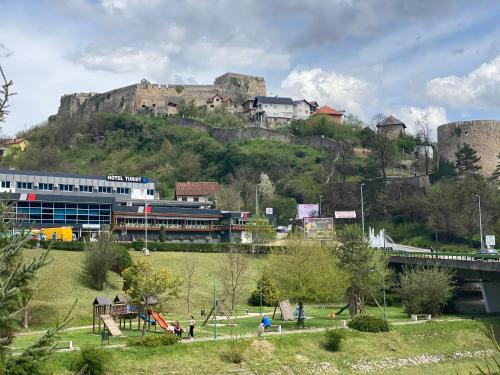 a group of people in a park in front of a mountain at Hotel Turist 98 in Jajce