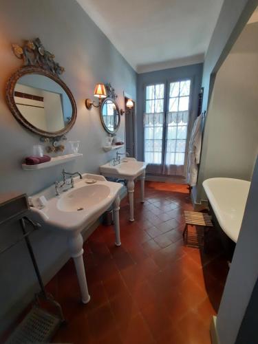 La salle de bains est pourvue de 2 lavabos et d'un miroir. dans l'établissement Château Sainte cécile Chambres D'hôtes / Guest house in Castle Château sainte cécile, à Nézignan-lʼÉvêque