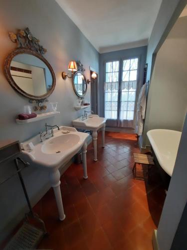 une salle de bain avec deux lavabos et un miroir dans l'établissement Château Sainte cécile Chambres D'hôtes / Guest house in Castle Château sainte cécile, à Nézignan-lʼÉvêque