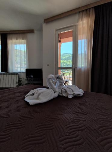 a bedroom with a bed with two towels on it at Стаи за гости ВЕНИ-ЕВ in Devin
