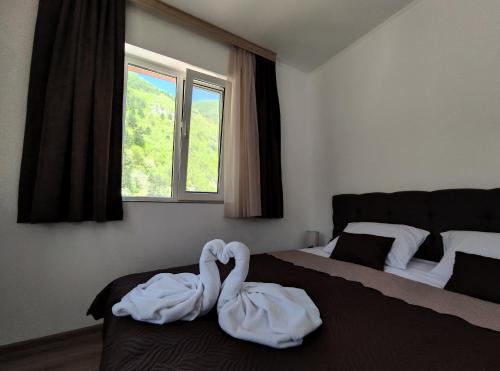 two swans sitting on a bed in a bedroom at Стаи за гости ВЕНИ-ЕВ in Devin