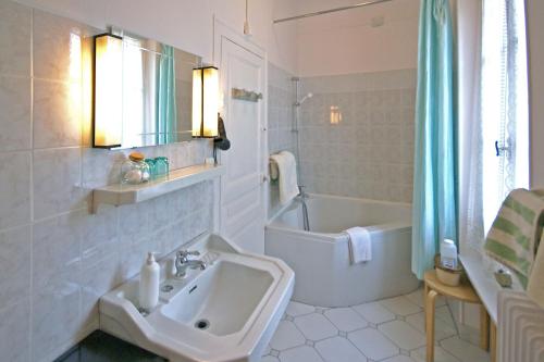 La salle de bains est pourvue d'un lavabo et d'une baignoire. dans l'établissement Appartements détente & nature - Domaine de La Thiau, à Briare