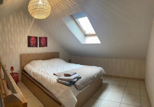 a attic bedroom with a bed and a skylight at Domus Basil in Tongeren