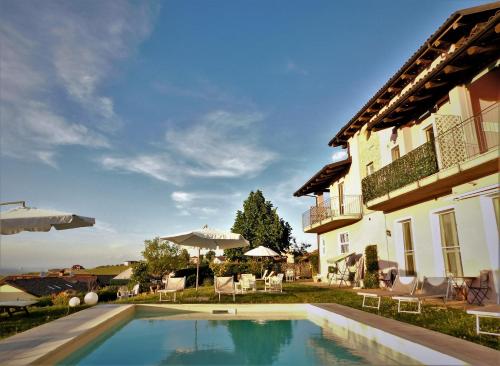 a swimming pool in front of a house at Domus Langhe B&B in Treiso