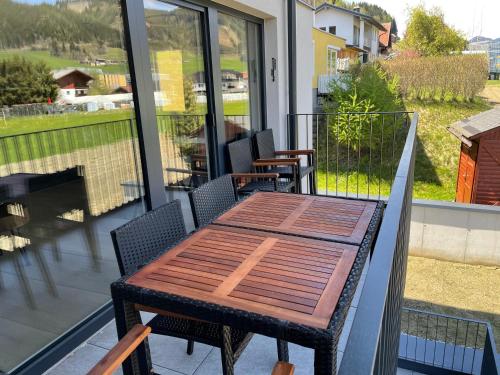 a wooden table and chairs on a balcony at Appartements Wehrhof by Schladmingurlaub in Schladming
