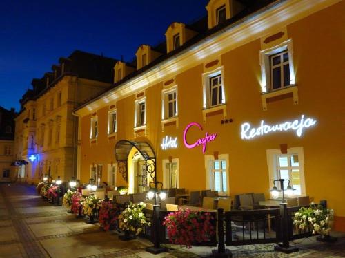 a building with a cafe on a street at night at Hotel Restauracja Caspar in Jelenia Góra