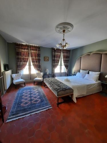une chambre avec un grand lit et deux fenêtres dans l'établissement Château Sainte cécile Chambres D'hôtes / Guest house in Castle Château sainte cécile, à Nézignan-lʼÉvêque