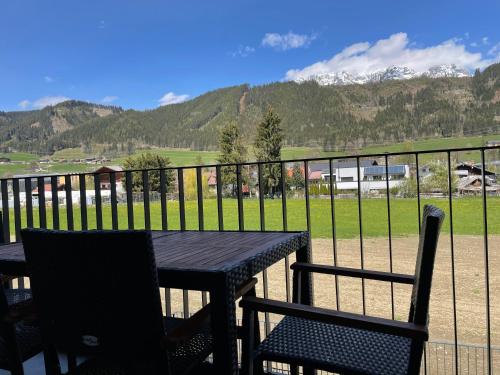 a table and chairs on a balcony with a view of a mountain at Appartements Wehrhof by Schladmingurlaub in Schladming