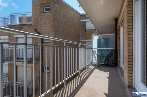 an empty balcony of a brick building with stairs at Atlantic 0504 in Koksijde