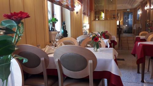 a restaurant with tables and chairs with flowers on them at Hôtel Restaurant Oberlé in Kilstett