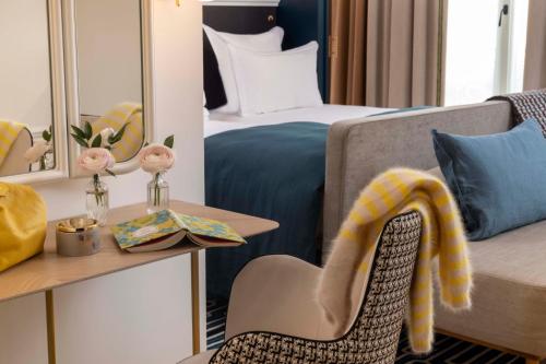 a hotel room with a bed and a chair and a mirror at Hotel Louvre Montana in Paris