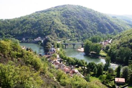 une rivière avec un pont au milieu d'une montagne dans l'établissement Chambres d'Hôtes Le Clos Ambels, à Ambialet