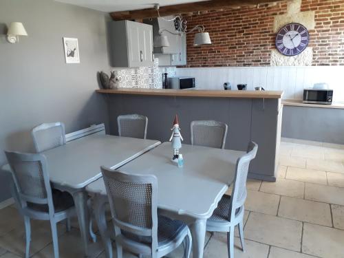 une salle à manger avec deux tables et des chaises ainsi qu'une cuisine dans l'établissement La Charmée, à Jonquières