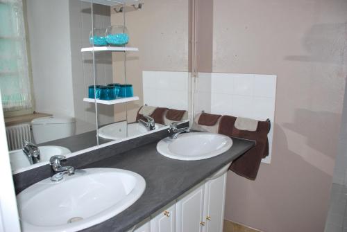 une salle de bain avec deux lavabos et un miroir dans l'établissement Chambres d'Hôtes Le Clos Ambels, à Ambialet