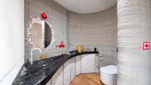 een badkamer met een wastafel, een spiegel en een toilet bij Residence Safari resort - Prvok in Borovany