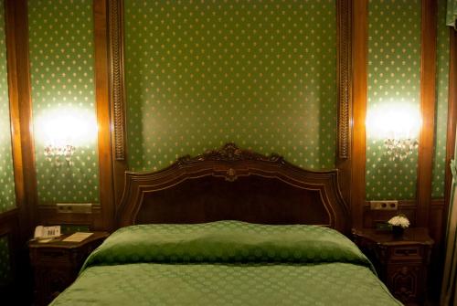 a bedroom with a bed and green polka dot wallpaper at Hotel Casa Capsa in Bucharest