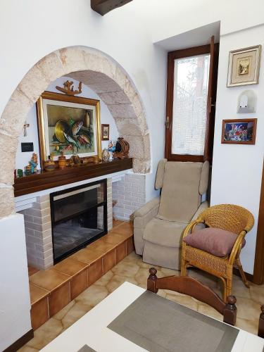 a living room with a fireplace and a chair at il trullo di giada e mattia in Alberobello