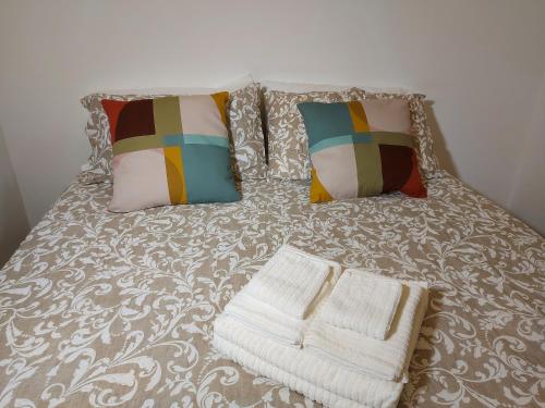 a bed with two pillows and two towels on it at il trullo di giada e mattia in Alberobello