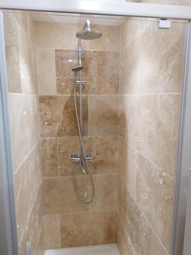 une douche avec pommeau de douche dans une salle de bain dans l'établissement Appartement PERIGUEUX Garage attenant Fibre Climatisation, à Périgueux