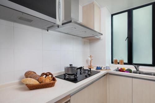 a kitchen with a stove and a basket of bread at Springdale Serviced Residence Guangzhou in Guangzhou