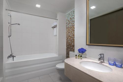 a bathroom with a sink and a tub and a toilet at Springdale Serviced Residence Guangzhou in Guangzhou