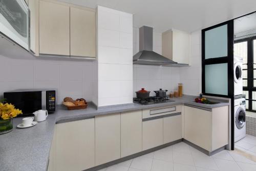 a kitchen with white cabinets and a stove at Springdale Serviced Residence Guangzhou in Guangzhou