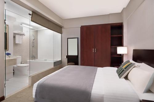 a bedroom with a large bed and a bathroom at Springdale Serviced Residence Guangzhou in Guangzhou