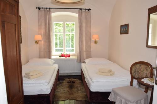 two beds in a room with a window at Hájovna hradu Houska in Doksy