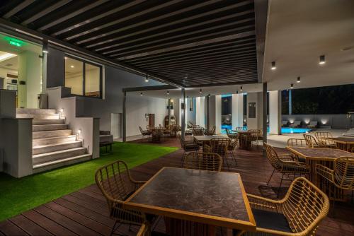 雅典的住宿－Glyfada Riviera Hotel，木制甲板上配有桌椅的庭院