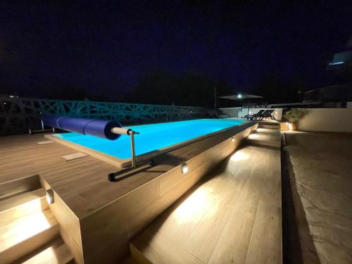 a swimming pool at night with lights on the deck at Apartment Lounge in Pula