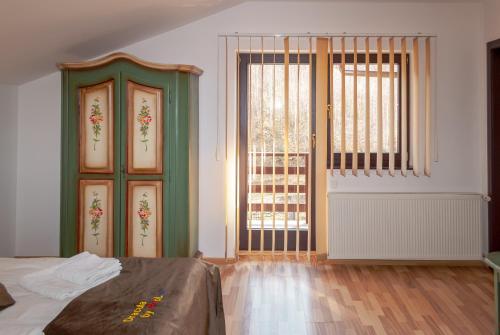 a bedroom with a bed and two large windows at Casa Dracula by Pro Lex in Bran