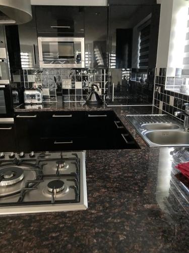 a kitchen with a stove top and a sink at Shorthorn Apartment, 53a Sea Road in Carlyon Bay