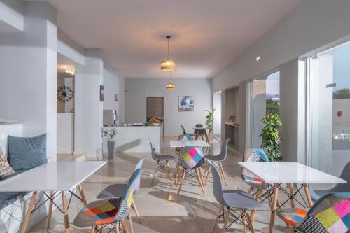 a dining room with white tables and chairs at Golden Sunlight Hotel by Estia in Gouves