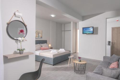 a room with a bed and a couch and a mirror at Golden Sunlight Hotel by Estia in Gouves
