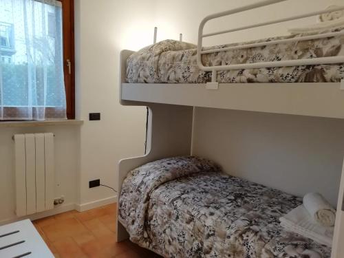 a bedroom with two bunk beds and a window at Re Lear Al Lago in Colà di Lazise