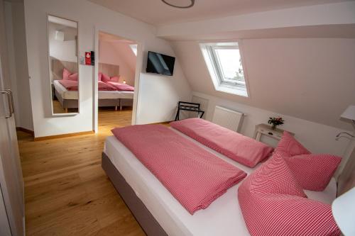 a bedroom with a bed with red sheets and a mirror at Ferienwohnung Altes Forsthaus Hella in Grebenhain