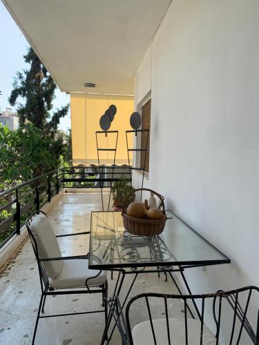a glass table and chairs on a balcony at Vintage 70s flat in Athens