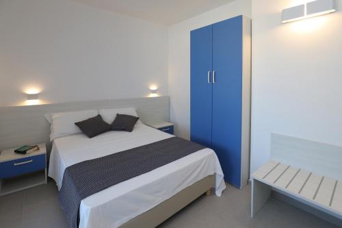 una camera con un grande letto e una porta blu di The Square Castelsardo a Castelsardo