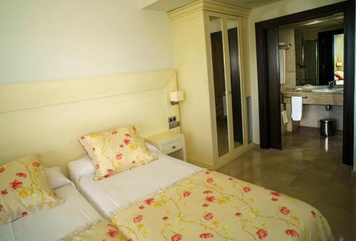 a bedroom with a bed and a bathroom with a sink at Senator Águilas in Águilas