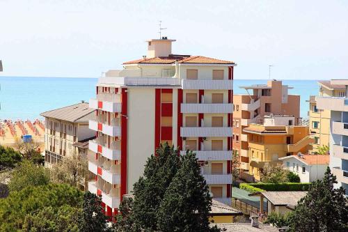 ビビオーネにあるApartments in Bibione 25582の赤と白の高層アパートメントビル